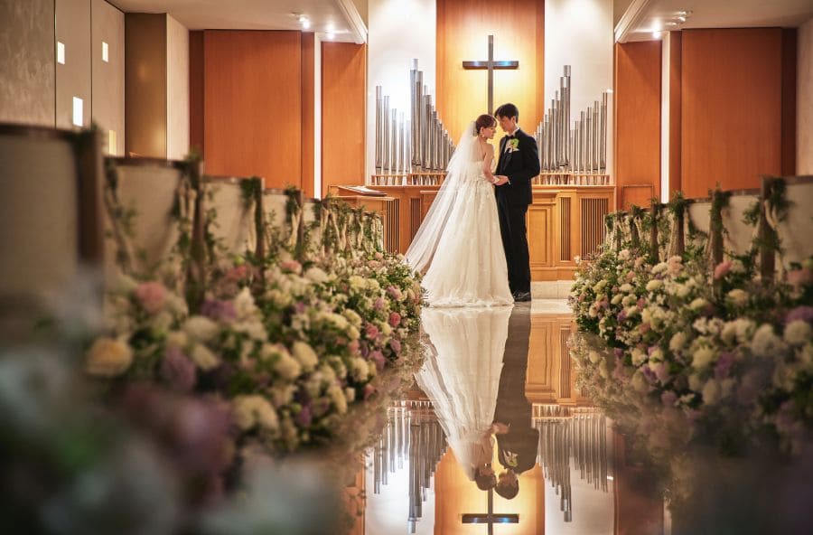 【上質で温かみのある挙式空間 】大理石のバージンロードが美しく輝くチャペルは、花嫁姿をより華やかに演出。 木のぬくもりを感じる落ち着いた空間のため、ゲストとの距離が近く、アットホームな挙式が叶います。 パイプオルガンや聖歌隊の音色も印象的で、記憶に残るセレモニーを実現できます。